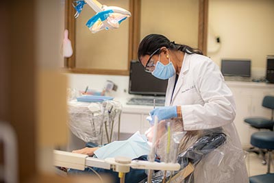 Dr. Anita Paulus performing oral surgery on a patient